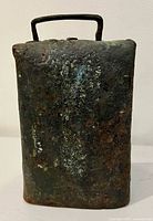 Front view of rusted rectangular cast iron cow bell