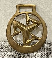 Front view showing Isle of Man triskelion brass ornament