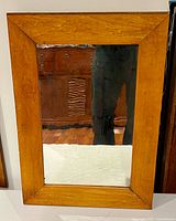 Front view of rectangular wood frame wall mirror