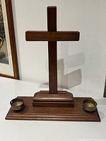 Full view of wooden cross with brass candle holders