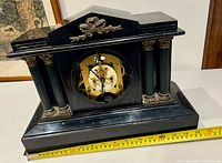 Front view of Ansonia mantle clock with tape showing approx 14 in width