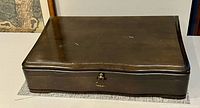 Closed wooden flatware box showing exterior finish and latch