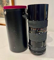 Lens standing beside black hard case