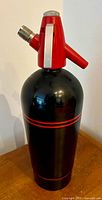 Front view of black and red aluminum seltzer bottle
