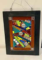 Full view of framed stained glass window with hanging wire