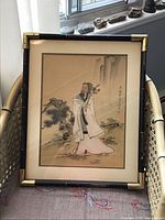 Full view of framed silk painting on chair