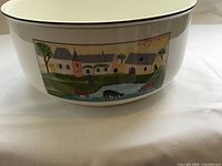 Side view showing village scene artwork on bowl
