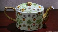 Full view of teapot showing floral pattern and gold handle/spout