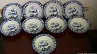 Nine matching blue and white Yuan pattern bowls arranged rim up showing interior decoration