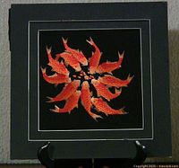 Full view of square embroidered goldfish artwork on stand