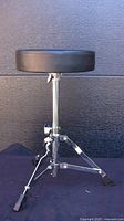 Front view of drummer's throne showing seat and tripod base