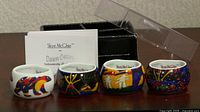 Four porcelain napkin rings with box and artist card