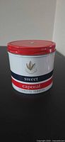 Front view of Sweet Caporal tobacco tin showing branding