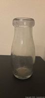 Front view of clear glass milk bottle
