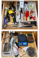 Drawer with assorted utensils showing citrus press, garlic press, spatulas, wooden spoons
