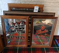 Front view of five framed beer advertising signs, showing Watneys and Stroh's in foreground