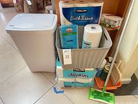 Overall lot showing trash can, paper goods, basket, Swiffer, dustpan with cleaners
