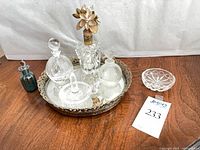 Entire lot on wood surface showing tray, four perfume bottles, ring holder, crystal dish