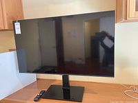 Front view of Samsung 43-inch TV on stand with remote