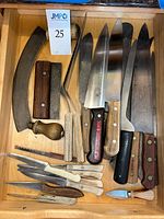 Drawer containing mezzaluna, bench scraper, wooden tamper, large knives, small knives and spreaders