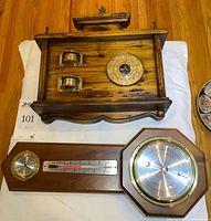 Both wall-mounted weather stations laid flat showing complete fronts