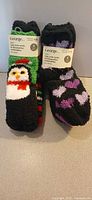 Front view of two packaged 4-pair packs showing tags and main sock designs (penguin, hearts)