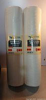 Two upright rolls of Vega disposable bed sheet