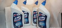 Front view of four Lysol toilet bowl cleaner bottles showing labels and caps