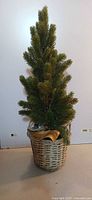 Full view of artificial Christmas tree in wicker basket