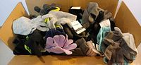 Open box showing large quantity of assorted color knit winter gloves