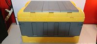 Front view of yellow and grey plastic contractor toolbox