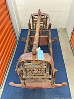 Full view of wooden rocking cradle from head end showing spindle sides and red painted finish