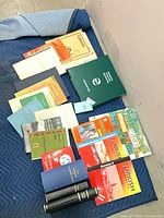 Overhead view of entire lot laid out on blue blanket, showing books, pocket dictionaries, hardcovers, binder