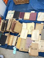 Overhead view of mixed bound books and loose pages spread on quilt