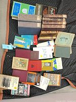 Overhead view of entire lot showing mixed hardcovers, paperbacks and leather-bound Arabic set