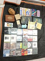 Top view showing all CDs, wooden items, books, ephemera spread on black blanket