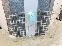 Front view of rectangular wire grid panel leaning against wall