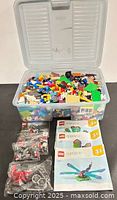 Tote of mixed LEGO bricks with manuals and parts bags
