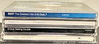 Stacked spines of four S Club 7 CDs showing album titles and catalog numbers