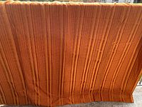 Full view of orange striped drapery panel hanging