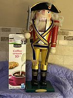 Full frontal view of nutcracker beside 1 L cream carton for scale