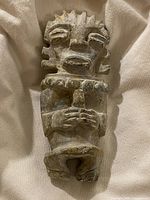 Full view of stone figurine on cloth background