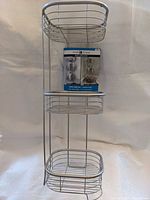 Full view of 3-tier metal bath shelf with packaging attached