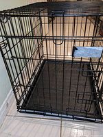 Front view of metal pet crate with door and pan