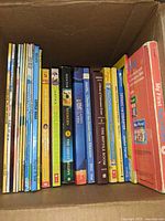 Box with row of approximately 21 thin early-reader books plus board book