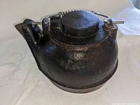 side view of cast iron kettle with lid in place