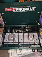 Open camp stove showing two burners and grate