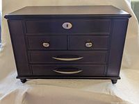 Front view of closed jewelry chest showing overall condition and hardware.