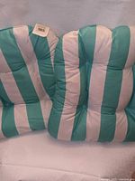 Front view of both striped patio cushions showing color, tufting and tags