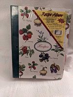 Front view of sealed recipe album binder with botanical design and product label